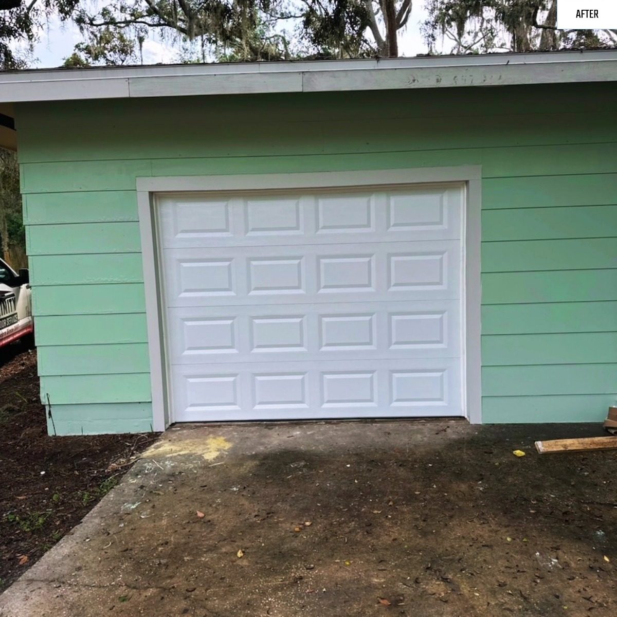 After: a boarded up garage opening finished with a new white door