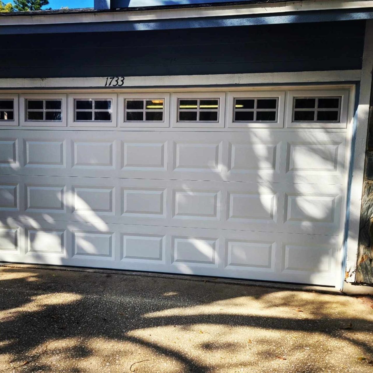After: a dated dark garage door replaced with a white sectional