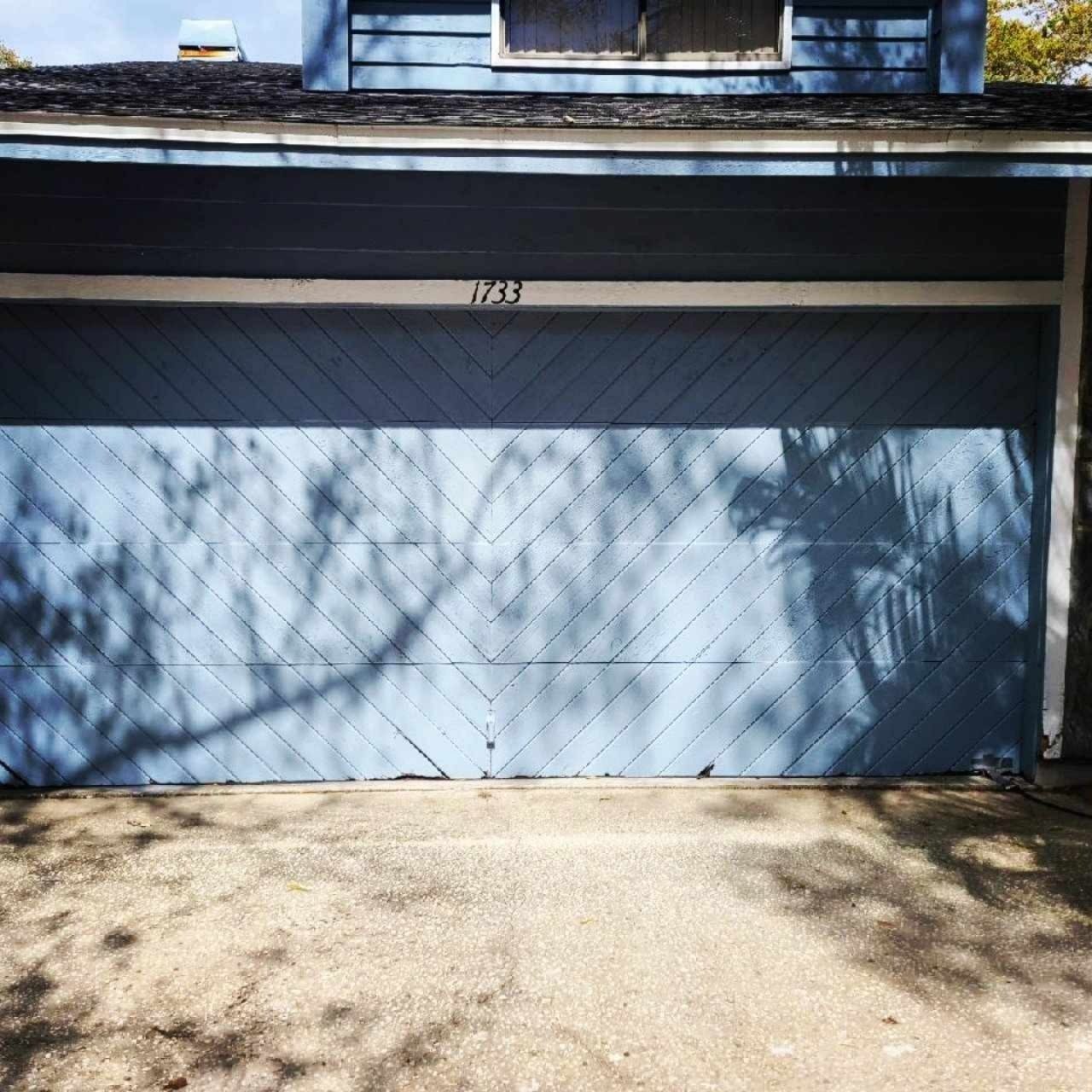 Before: a dated dark garage door replaced with a white sectional